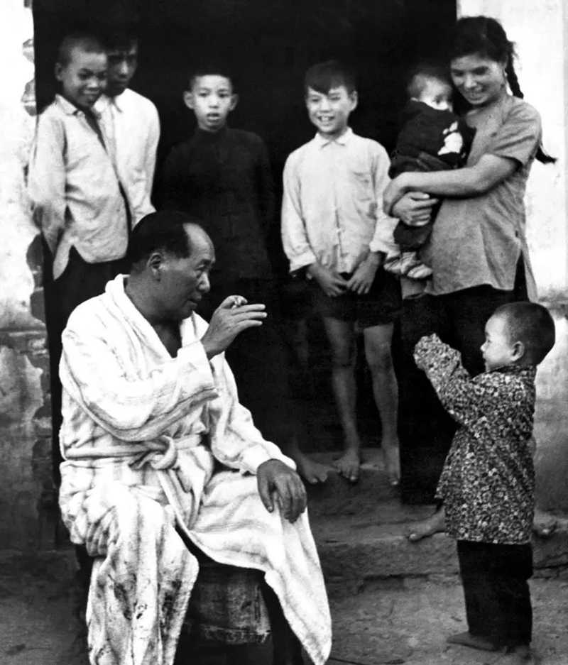 這是1958年毛主席重回老家湖南，暢游湘江后，在農(nóng)家門口與小孩打招呼。.jpg
