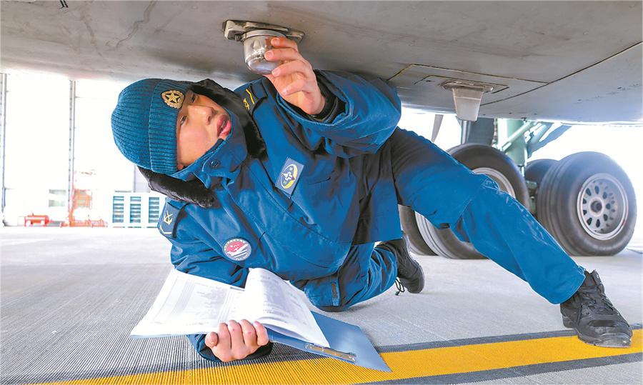 機務(wù)兵冒著嚴(yán)寒檢查戰(zhàn)機。.jpg